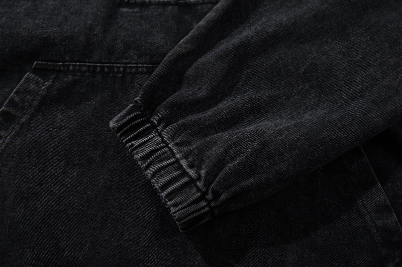 Close-up of ribbed elastic cuff on black denim hoodie sleeve