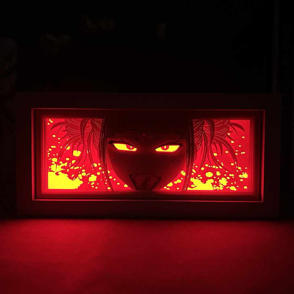 The Chainsaw Man Anime Light Box – Himeno 3D LED Lamp showcases an illustrated face with intense eyes and an open mouth. Dynamic color-changing effects and splattered patterns give it a captivating energy, reminiscent of Himeno from Chainsaw Man.