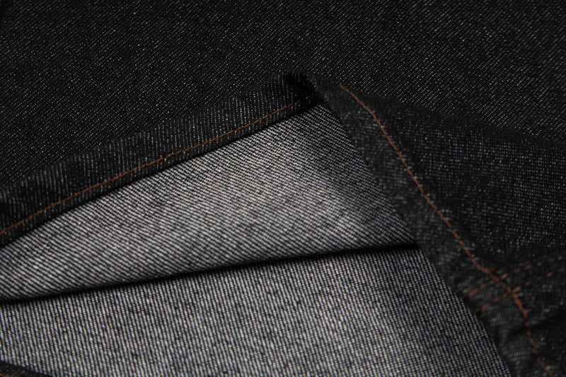 Close-up of dark wash denim cuff showing inner fabric and hem stitching