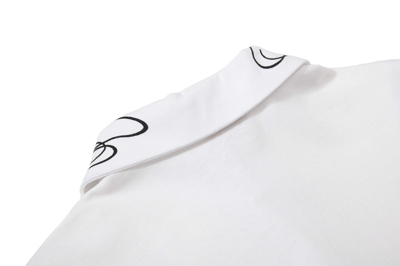 Close-up of a white cotton polo tee with black star line details and folded collar on a clean background