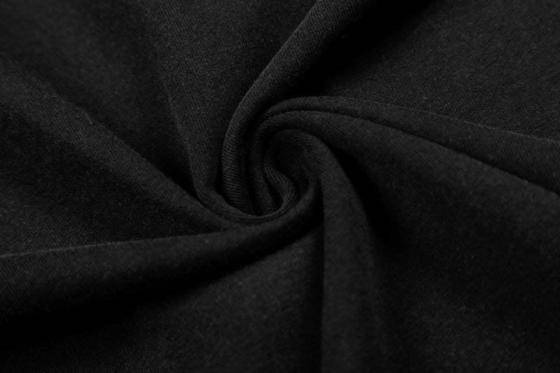 Close-up of black fabric with a spiral fold, showcasing the tee’s dark punk streetwear style and texture