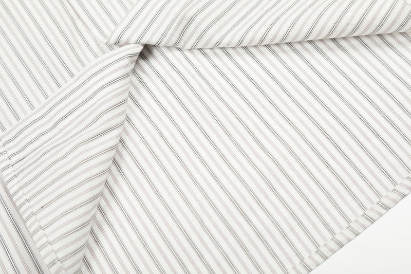 Close-up of layered cream striped shirt fabric showing seams and drape