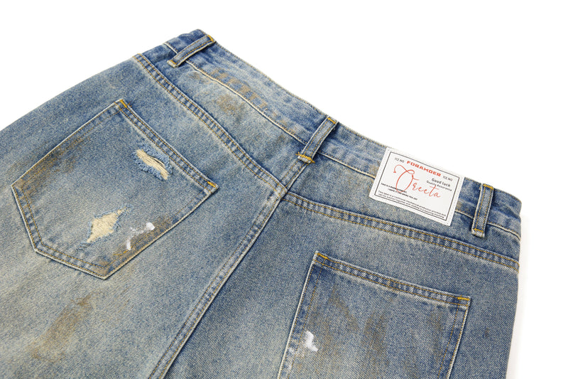Close-up of back waistband, pocket, and brand label on faded denim pants