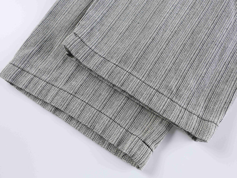 Cuffed hem of gray wide-leg pants with visible stitched edge and folded fabric