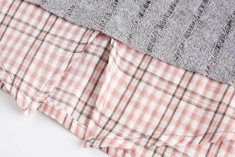 Pink plaid hem lining under gray sheer mesh top, close-up