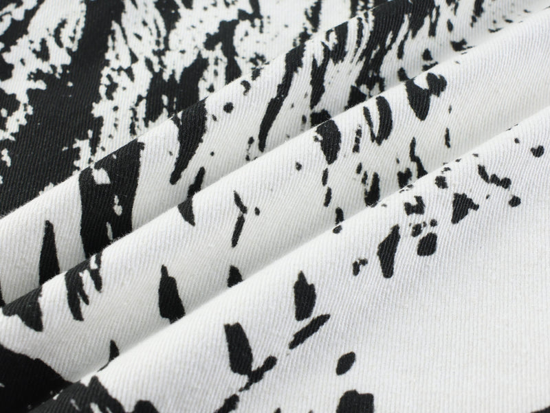 Close-up of black and white animal print denim fabric with visible twill texture