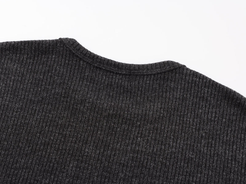 Close-up of black ribbed crew neck collar and shoulder seam