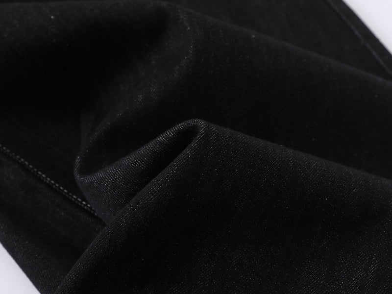 Close-up of black denim fabric texture and seam folds