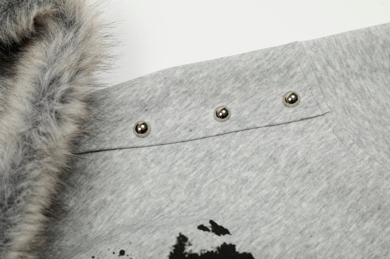 Close-up of light gray hoodie shoulder with faux-fur collar and silver stud detail