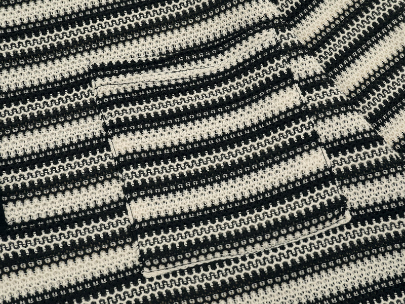 Close-up of black and cream striped knit fabric and chest pocket detail
