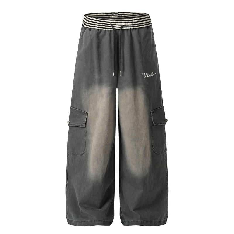 Front view of charcoal washed wide-leg cargo pants with striped elastic waist and side flap pockets