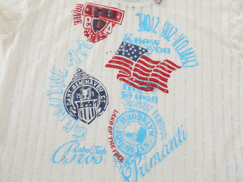 Close-up of front graphic on cream distressed shirt with red, blue, and navy retro prints