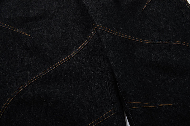 Close-up of curved side seam stitching on black denim pants