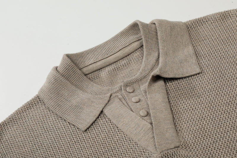 Beige open knit polo shirt with ribbed collar and button placket, laid flat on a white background