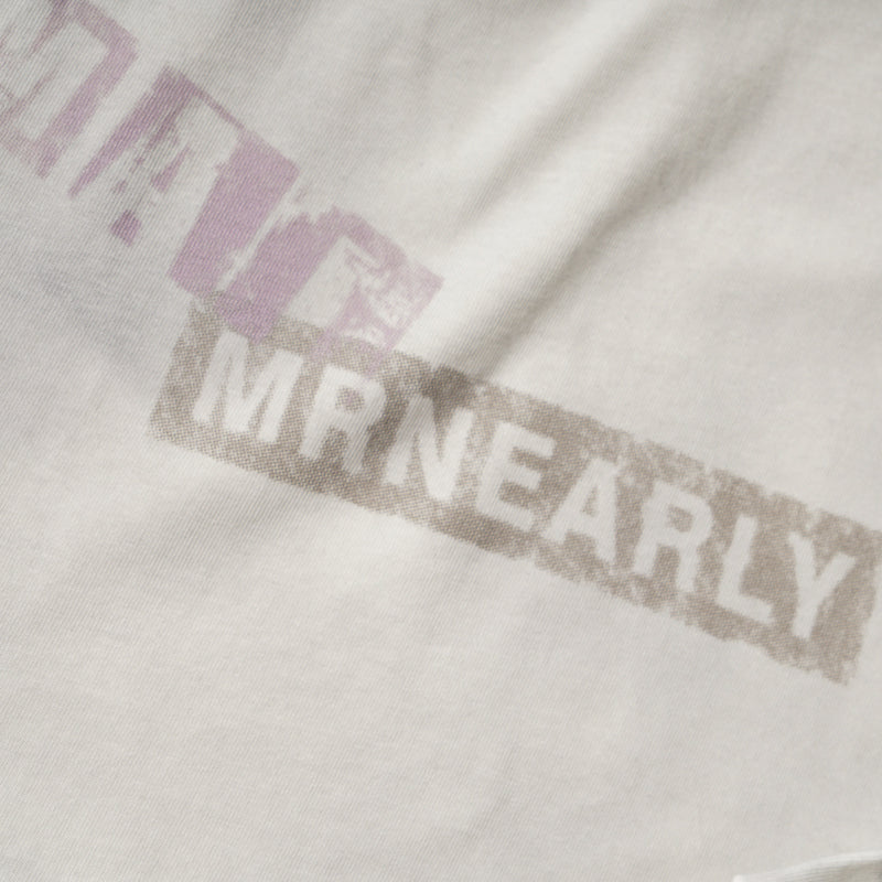 Close-up of purple block text print with partial brown lettering on cream fabric