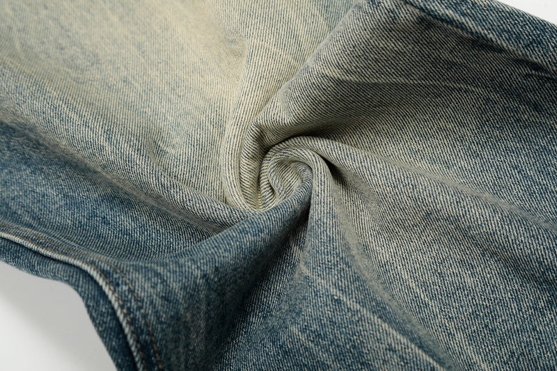 Close-up of twisted faded blue denim showing fabric texture and light wash contrast