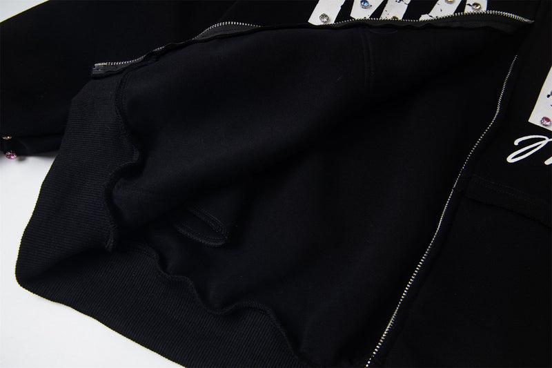 Close-up of black hoodie front pocket and side seam with zipper