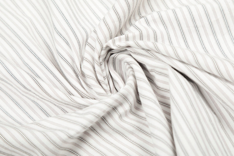 Close-up of gathered cream striped shirt fabric with soft folds