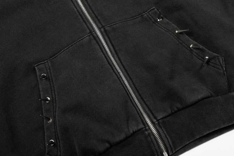 Close-up of front pockets and center zipper on black studded hoodie