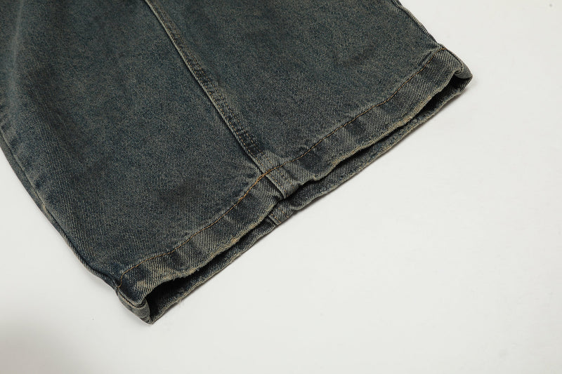 Close-up of hem on dark washed wide leg jeans with raw edge stitching