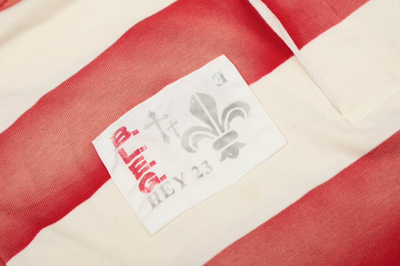 Close-up of small printed patch on cream and red striped rugby polo shirt