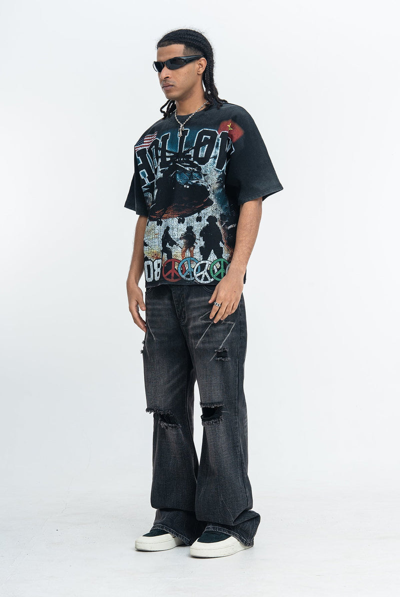 Black oversized vintage-washed graphic tee with war-themed print styled with baggy distressed jeans and sunglasses