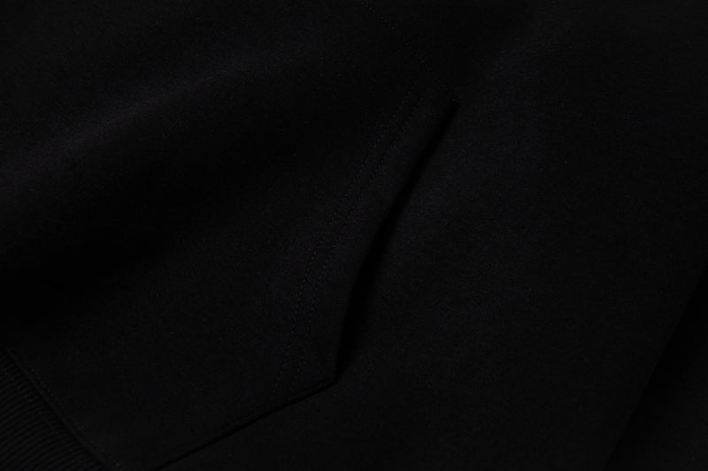 Close-up of black hoodie fabric showing stitched seam line and drape