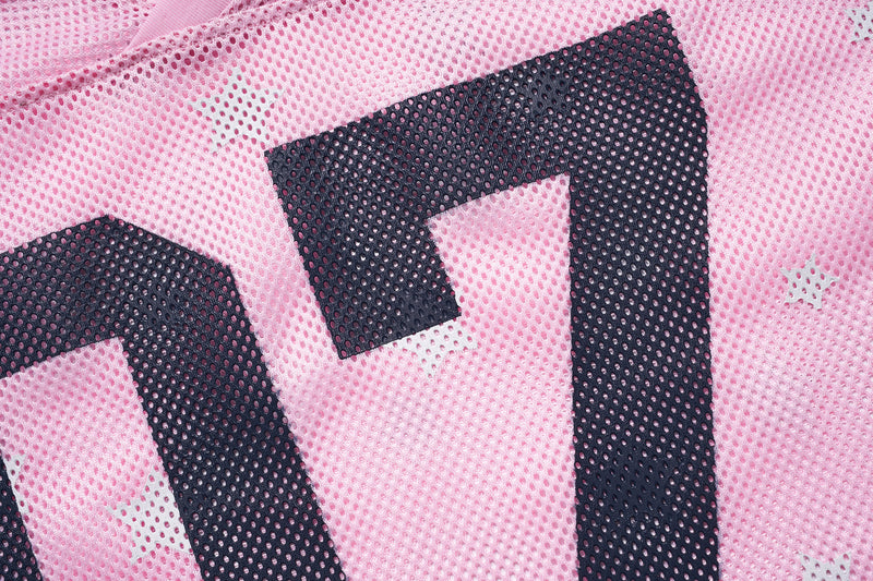 Close-up of pink mesh varsity jersey with oversized black star print and perforated athletic texture