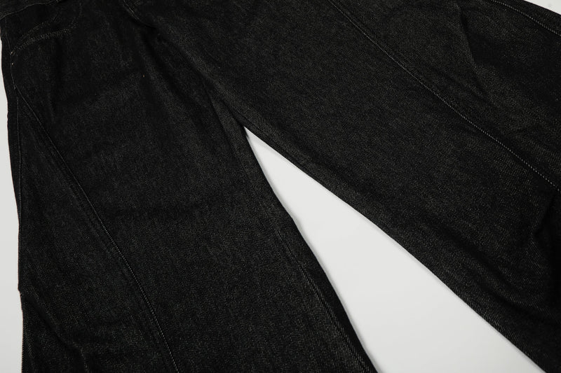 Black denim pant legs laid flat, showing wide-leg cut and panel seam lines