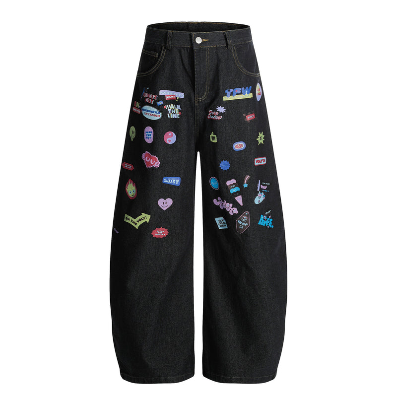 Front view of black wide-leg denim pants with colorful graphic patches