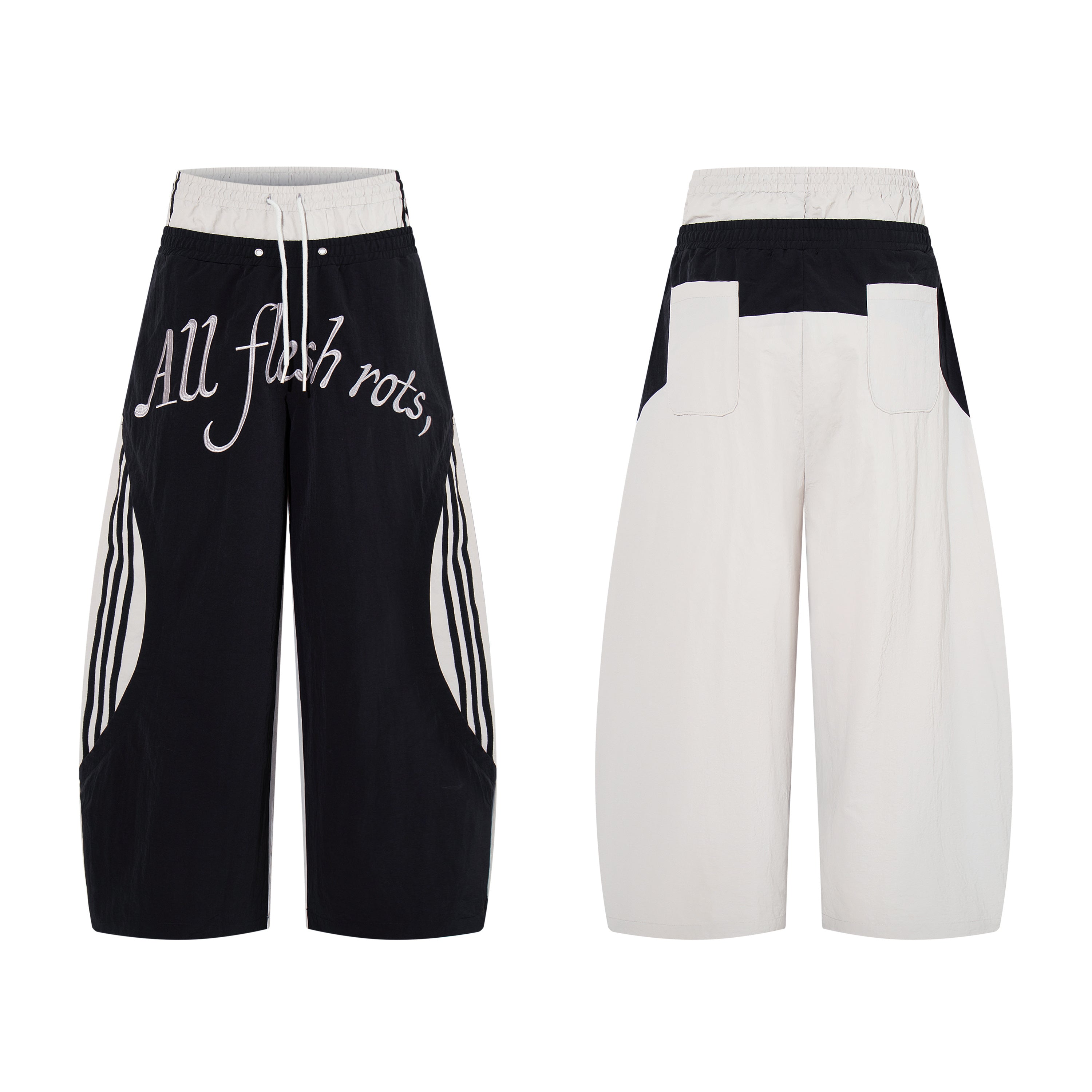 Front view of black wide-leg track pants with cursive script graphic print and cream contrast side panels