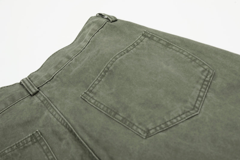 Close-up of olive green pants back pocket with stitched edge detail