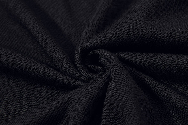 Close-up of black knit fabric with soft folds, highlighting the textured material of a vintage graphic polo shirt