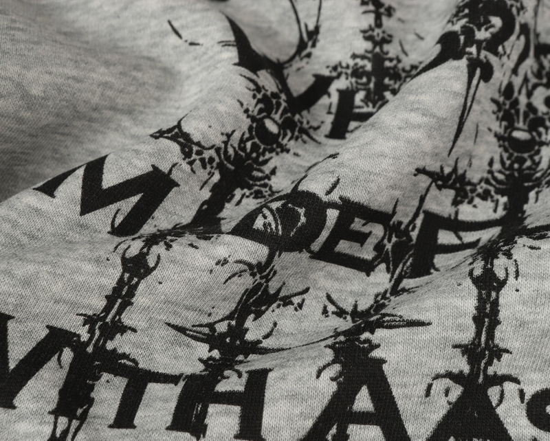Close-up of black gothic text and decorative print on heather gray hoodie fabric