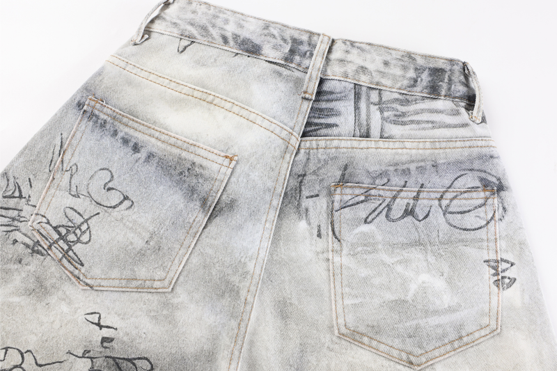 Close-up of back waistband and patch pockets on gray washed graffiti denim pants