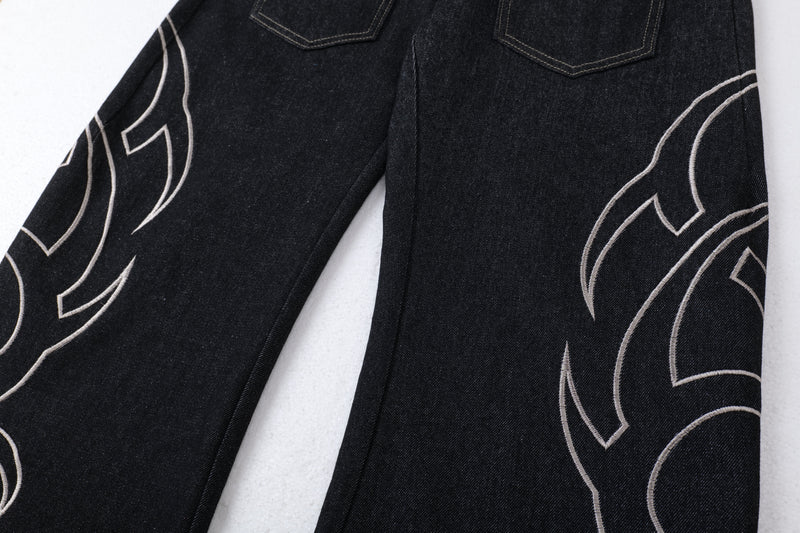 Rear view of dark denim jeans showing back pockets and tribal embroidery on both legs
