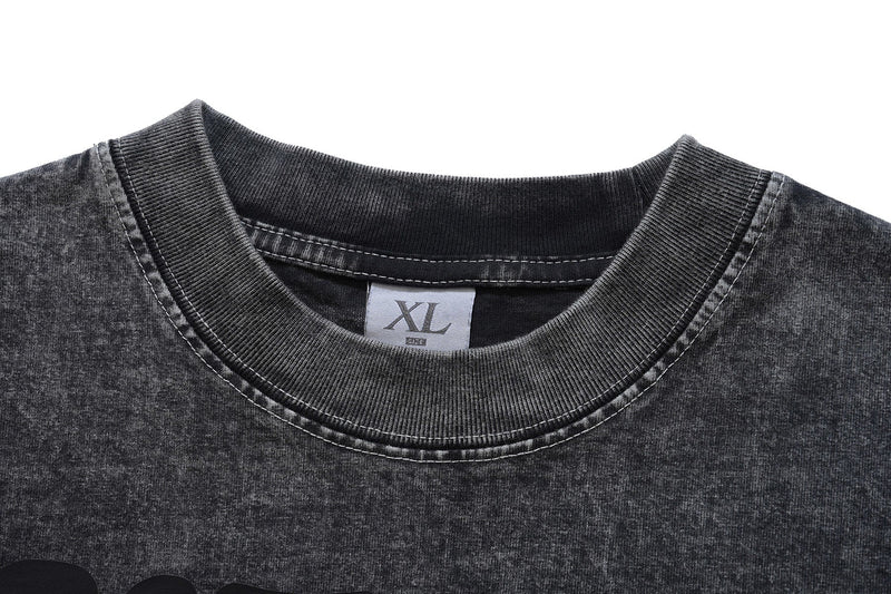 Close-up of a vintage wash black graphic tee with ribbed crew neckline and XL size label