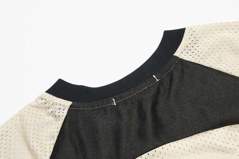 Close-up of a black and beige mesh jersey collar with visible stitching and sporty streetwear detailing