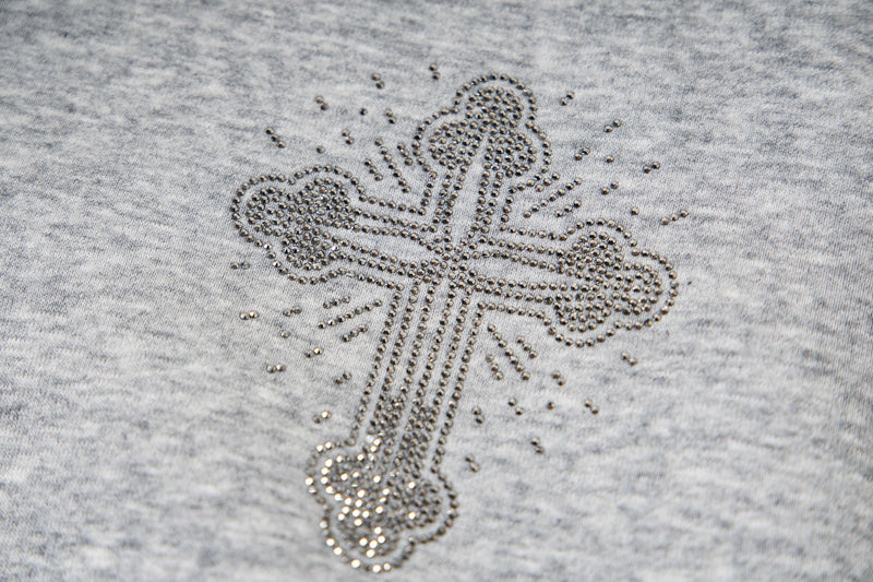 Close-up of rhinestone cross graphic on light gray fleece hoodie front