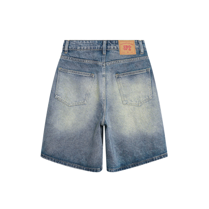 Back view of faded wide-leg denim shorts with patch pockets and tan logo label at waistband
