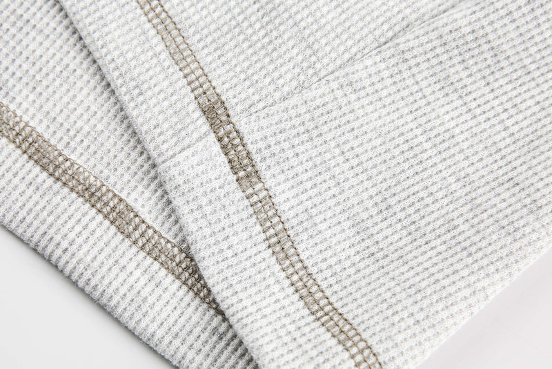 Close-up of white waffle-knit hem with visible topstitching and ribbed texture