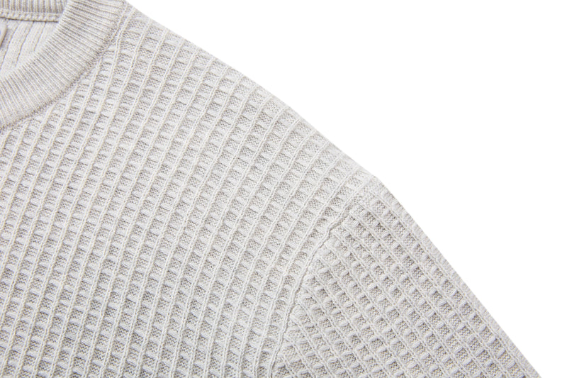 Close-up of a cream waffle knit short-sleeve sweater with textured cotton blend fabric and ribbed detailing