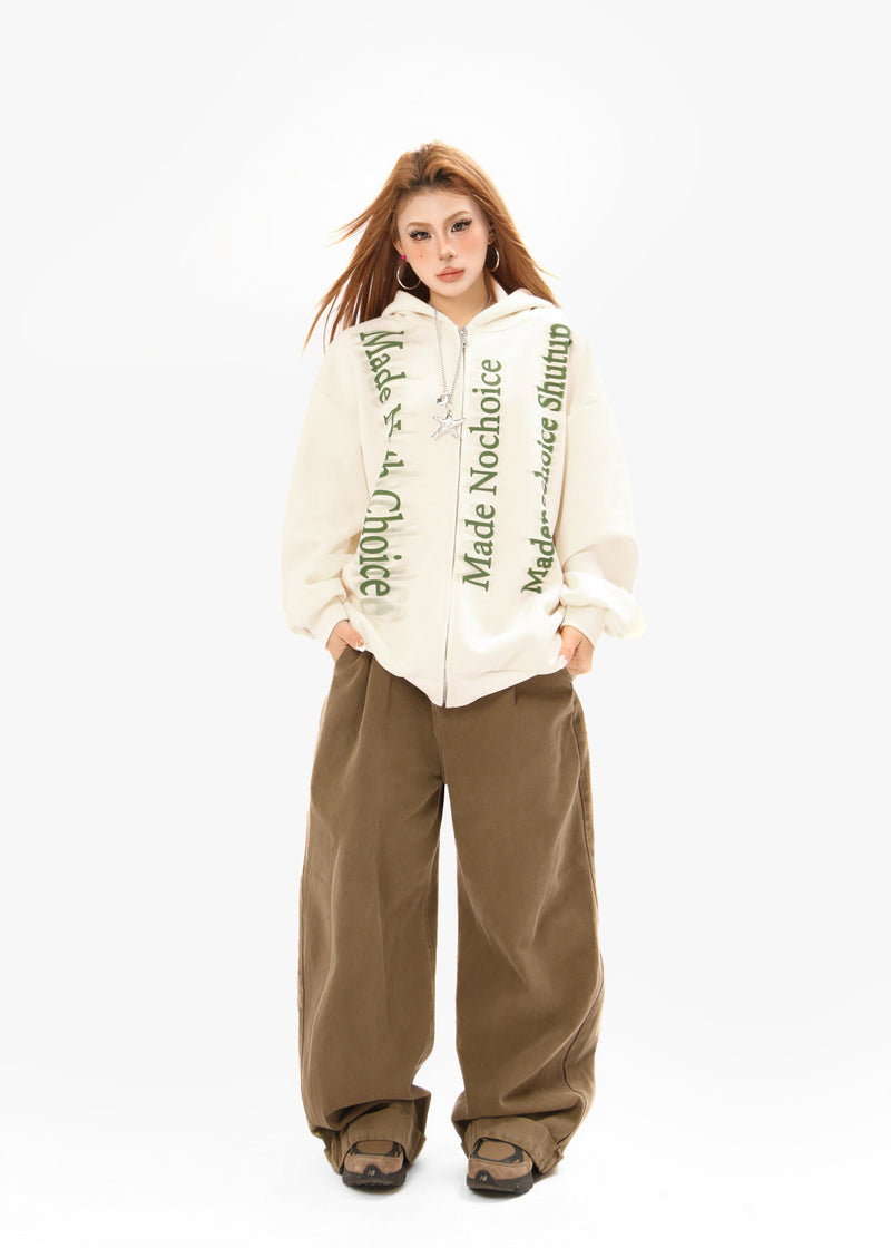 Cream zip hoodie full-body model view with green gradient lettering and wide pants