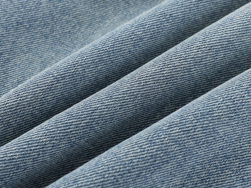 Close-up of light blue denim fabric with diagonal folds