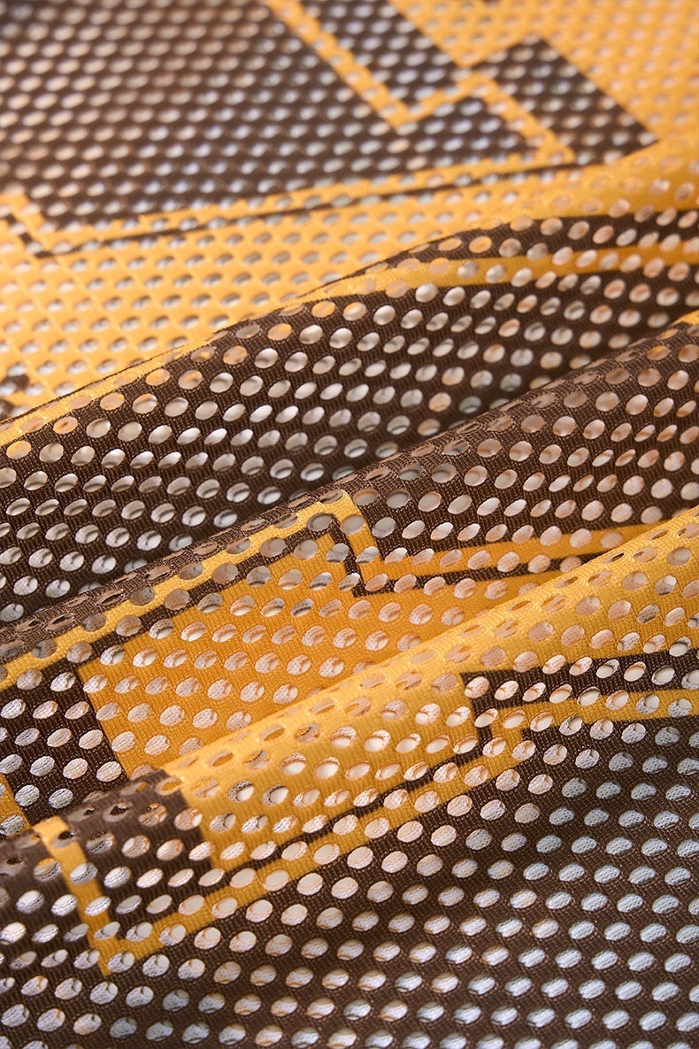 Close-up of brown and gold mesh jersey fabric with retro star pattern and perforated texture