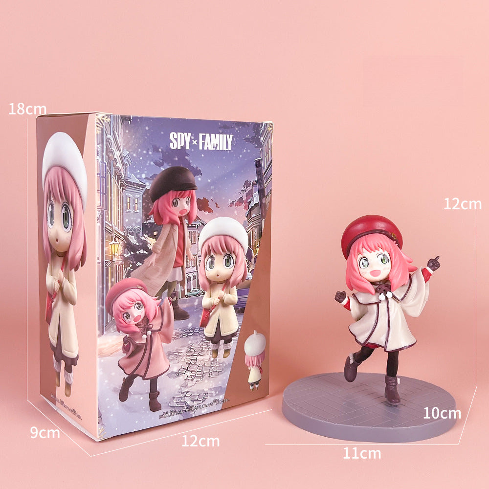 The Spy x Family Detective Anya PVC Figure Set, featuring the movie version of Anya with her signature pink hair, red beret, white coat, and black shoes, stands 14 cm tall in 4 poses. The packaging elegantly displays a snowy cityscape backdrop adorned with both figurine and box dimensions.