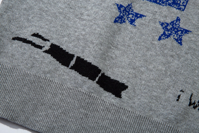 Close-up of lower front graphic on gray sweater showing black bar motif and blue star print