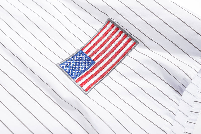 Close-up of American flag patch on white pinstripe baseball shirt hem