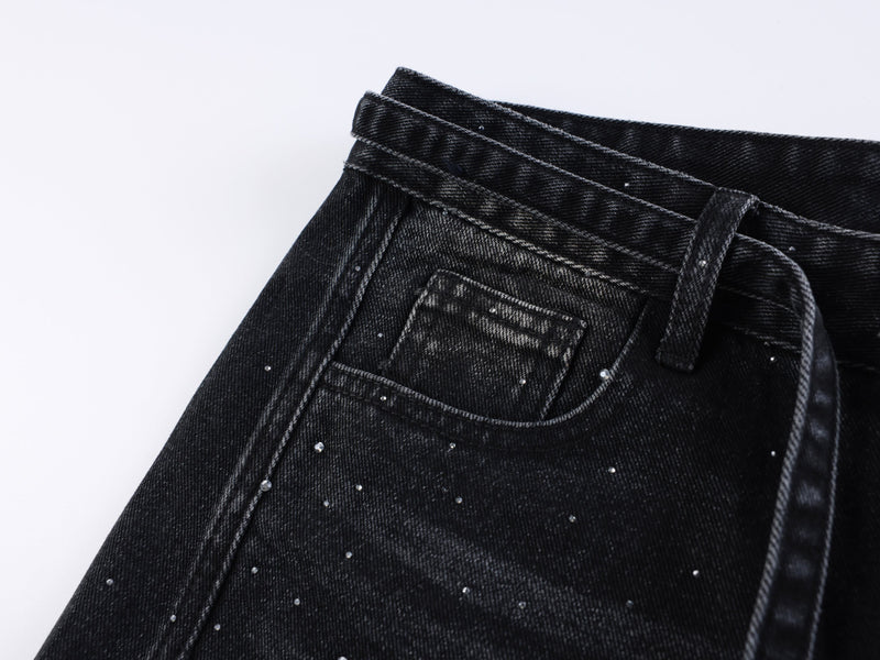 Black denim front pocket close-up with rhinestone speckles and stitching