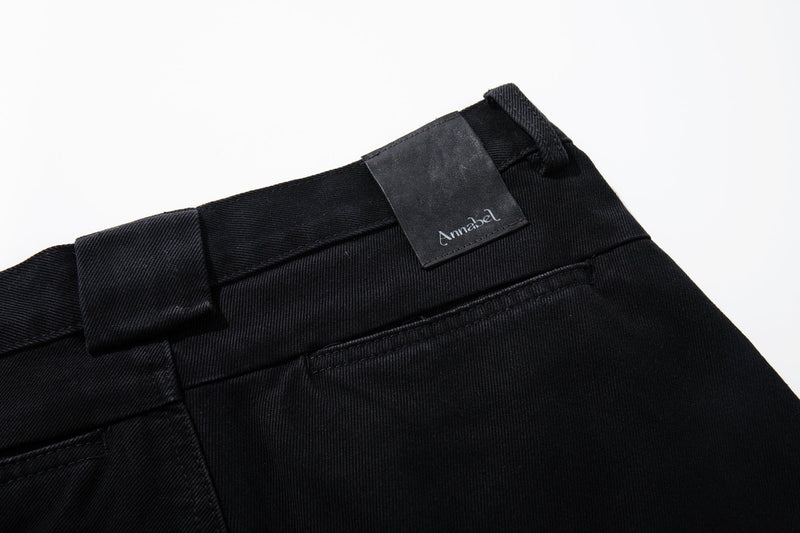 Close-up of black denim waistband with Annabel label and belt loop detail